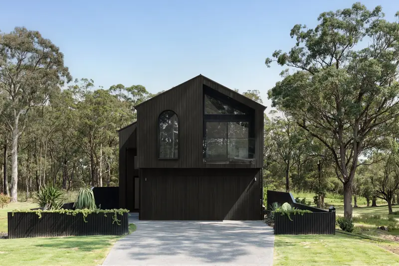 After: the dark timber-clad Huskisson Duplex by CKS Projects on the same bushland block